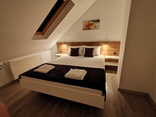 尼什Niš City Center Guest House的一间卧室配有一张床,上面有两条毛巾