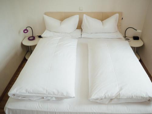 奥巴拉马高加尼阿梅高尔霍夫酒店的白色的床、白色床单和枕头