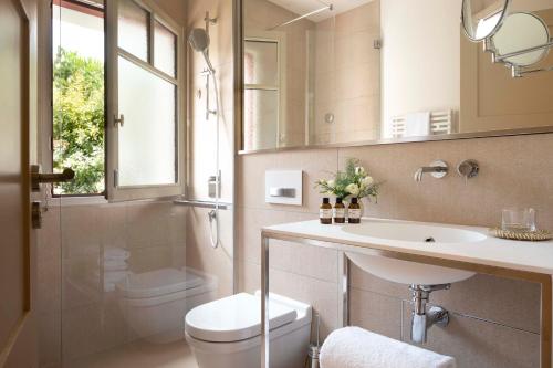 派拉索梅Villa du Pyla的一间带水槽、卫生间和镜子的浴室