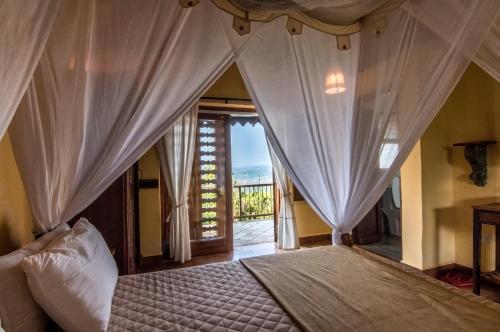 达博利SaffronStays Villa 270, Dapoli的一间卧室配有带窗帘的床和窗户