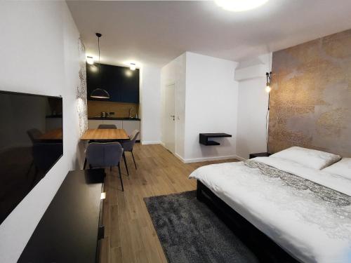 华沙Come&Stay apartments Wola的一间卧室配有一张床、一张桌子和一张书桌