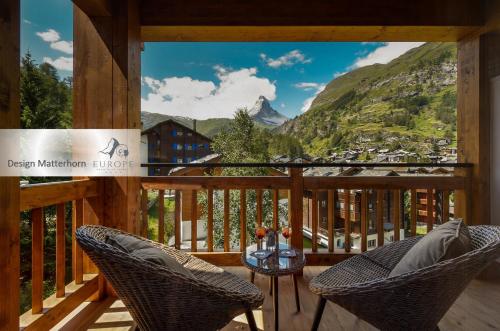 采尔马特欧洲酒店和温泉中心的阳台配有2把椅子和1张桌子,享有山景。