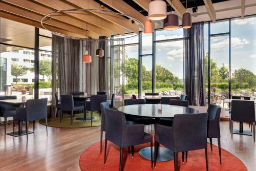 福尼布博览会品质酒店的用餐室配有桌椅和大窗户