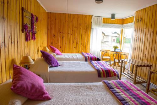百内三塔德尔佩恩酒店的酒店客房配有两张带紫色枕头的床