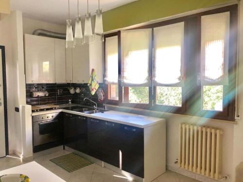 马里纳·迪·比萨Casa del Sole - Sunshine Home的厨房配有水槽、炉灶和窗户。