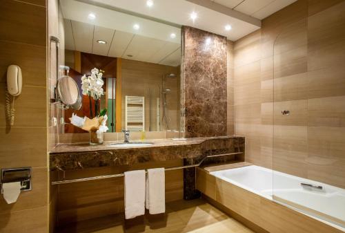 瓦伦西亚Eurostars Acteón的带浴缸、水槽和镜子的浴室