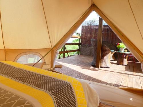 圣吕斯Kawaida - Hébergement insolite - Glamping Makazi的帐篷,配有带桌子和桌子的木制甲板