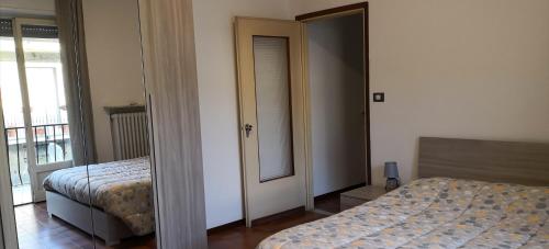 卡萨莱蒙费拉托Casa della Sala Spada的一间卧室配有两张床和镜子