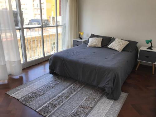 罗萨里奥Depto centrico, 90 m2, 2 habitaciones的一间卧室设有一张床和一个大窗户