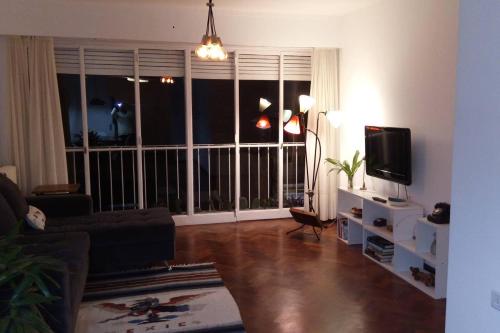 罗萨里奥Depto centrico, 90 m2, 2 habitaciones的客厅设有大窗户和电视。