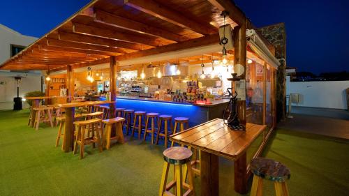 马斯帕洛马斯FBC福图尼度假村 - 仅限成人的一间带木凳的酒吧和一间带厨房的酒吧