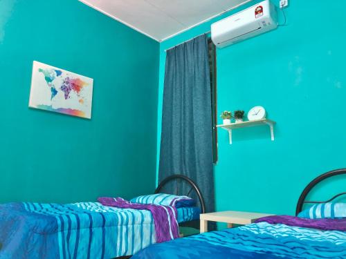 波德申Homestay Addin的蓝色墙壁客房的两张床