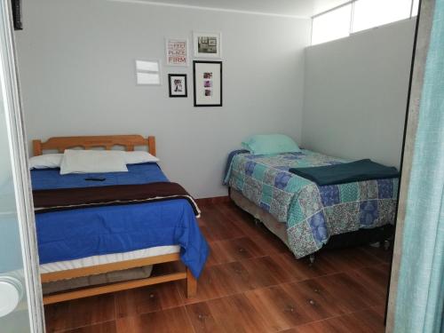 塞鲁阿苏尔蓝山海滩度假屋的一间卧室配有两张床和镜子