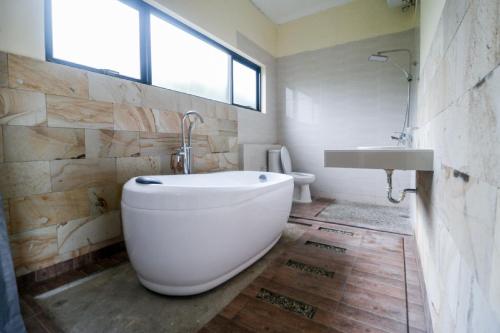棉兰RedDoorz Plus near Kualanamu Airport的浴室配有大型白色浴缸和水槽
