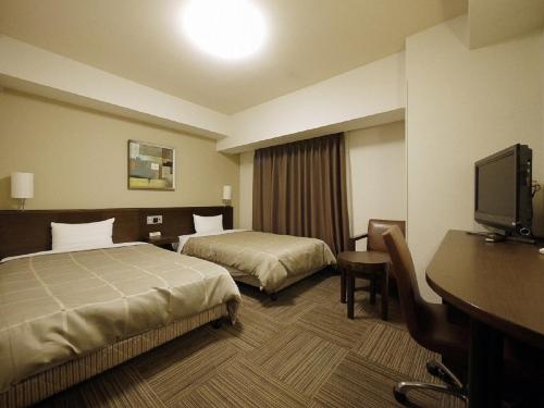 名取市名取罗特茵酒店的酒店客房配有两张床和一张书桌