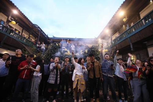 丽江丽江背包十年青年旅舍的一群人站在人群中,手放在空中