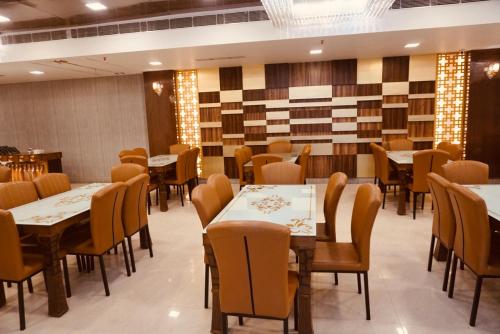 新德里Amora Rooms Dwarka的一间在房间内配有桌椅的餐厅