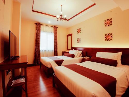 科隆巴拉望科隆阳光酒店的酒店客房设有两张床和电视。