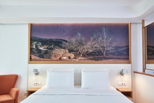 海若克利欧橄榄绿酒店的一间卧室配有一张壁画床