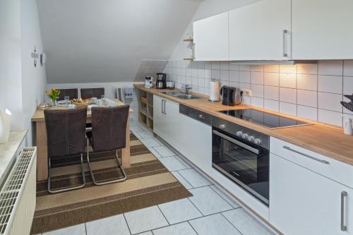 OstochtersumNordsee-Nest的厨房配有白色家电和台面