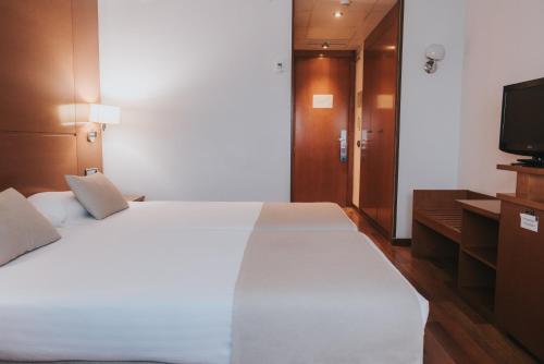 穆尔西亚Allegro Murcia Azarbe的卧室配有一张白色大床和电视。