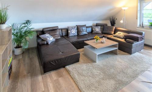 OstochtersumNordsee-Nest的客厅配有棕色皮沙发和桌子