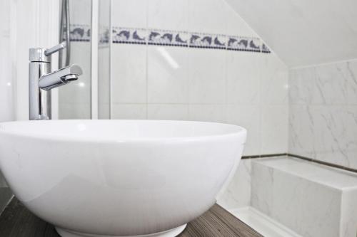 圣梅尔林BY THE BEACH Harlyn Bay的白色的浴室设有水槽和淋浴。