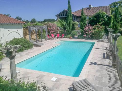 Le HougaBeautiful farmhouse with private pool的一个带椅子的庭院和房子的游泳池