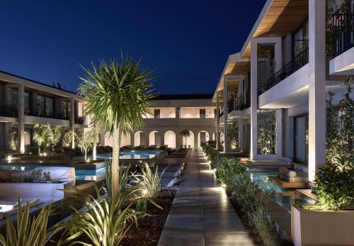 蒂锡利维Contessina Suites & Spa - Adults Only的享有大楼外部景色,晚上设有游泳池