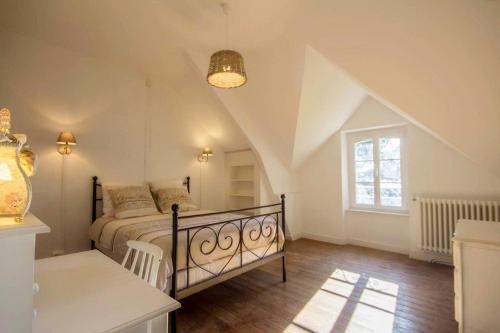 米济亚克Villa des Mimosas的一间卧室配有一张床、一张桌子和一个窗户。