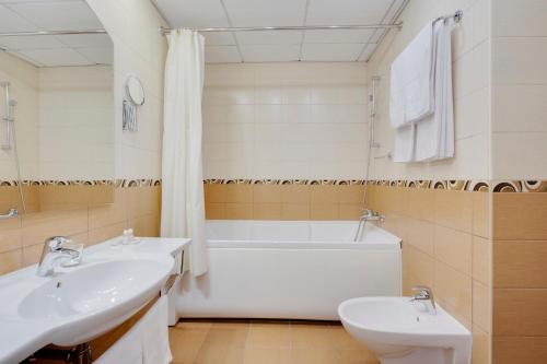 莫斯科马克西玛全景酒店的一间带两个盥洗盆、浴缸和卫生间的浴室