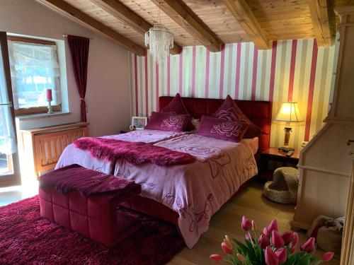 米特西尔Gästehaus Wimmer的一间卧室配有一张带紫色枕头的大床