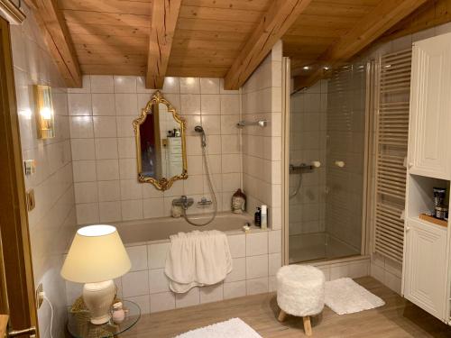 米特西尔Gästehaus Wimmer的带淋浴、镜子和灯的浴室