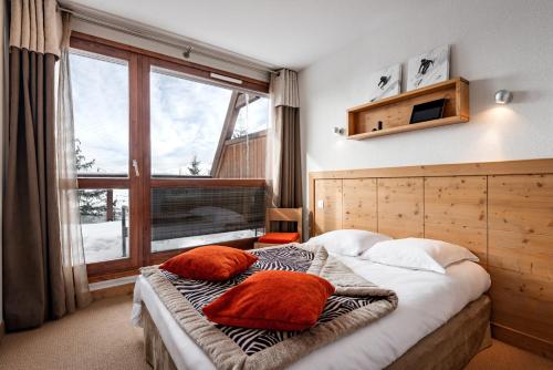 阿克 1600travelski home premium - Résidence Le Roc Belle Face 4 stars的一间卧室配有一张带两个枕头的床