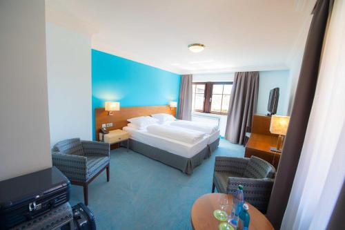 罗滕堡罗腾堡普瑞兹酒店的酒店客房,配有一张床和两把椅子