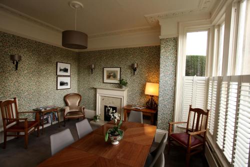 哈罗盖特Ascot House的客厅配有桌椅和壁炉
