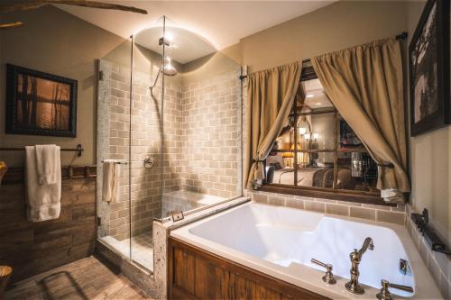 孟菲斯Big Cypress Lodge的一间带大浴缸和淋浴的浴室