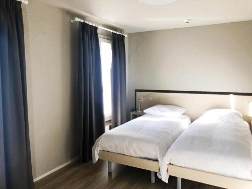 ContheyHotel pas de Cheville的一间卧室配有一张带白色床单的床和一扇窗户。