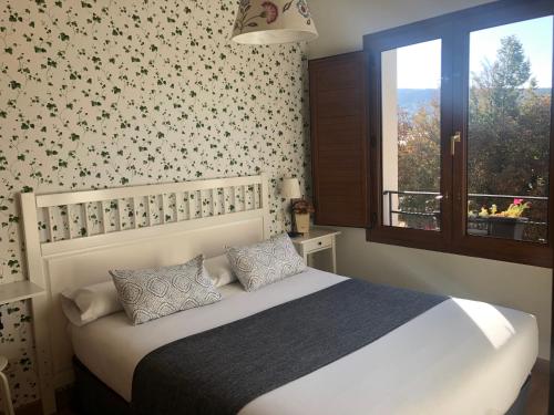 La Pradera de NavalhornoCasa de Navalhorno Valsain的卧室配有白色的床和窗户。