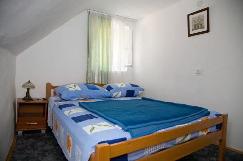 斯普利特梅特宇斯卡公寓的一间卧室配有一张带蓝色床单的床和一扇窗户。