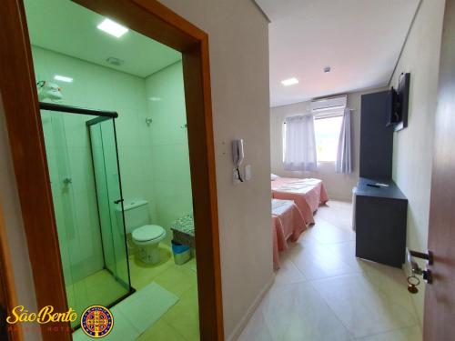 阿帕雷西达São Bento Palace Hotel的客房设有一张床和一间带镜子的浴室