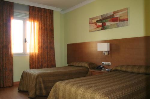 马德里欧罗巴皮尔塔4C酒店的酒店客房设有两张床和窗户。
