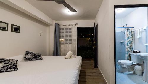 科苏梅尔Vacation Rental - Standard Room at Casa Cocoa的一间带白色床的卧室和一间浴室