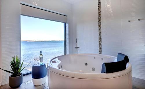 林肯港Limani Motel的带浴缸的浴室和大窗户