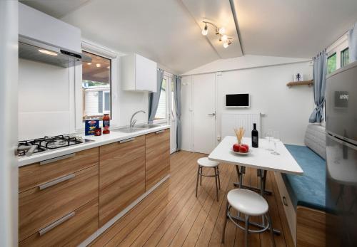 莱比锡KNAUS Campingpark Leipzig的小厨房配有白色台面和桌子