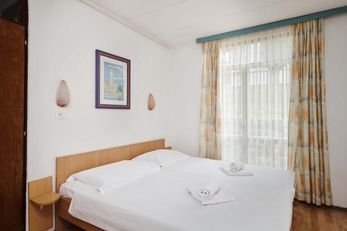 波雷奇Apartments Astra Plava Laguna的卧室配有白色的床和2条毛巾