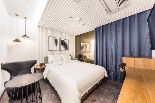 首尔Forestar Hotel Sinchon的一间卧室配有一张大床、一张桌子和一把椅子