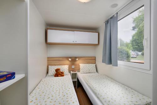 纽伦堡纽伦堡诺斯露营地的一间小卧室,配有两张床和泰迪熊