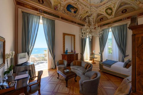 圣玛格丽塔-利古雷尹朋里阿雷皇宫酒店的一间带吊灯的客厅和一间带沙发和椅子的房间