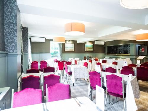 葛特纳格林盖博尔斯酒店的用餐室配有粉红色的椅子和桌子